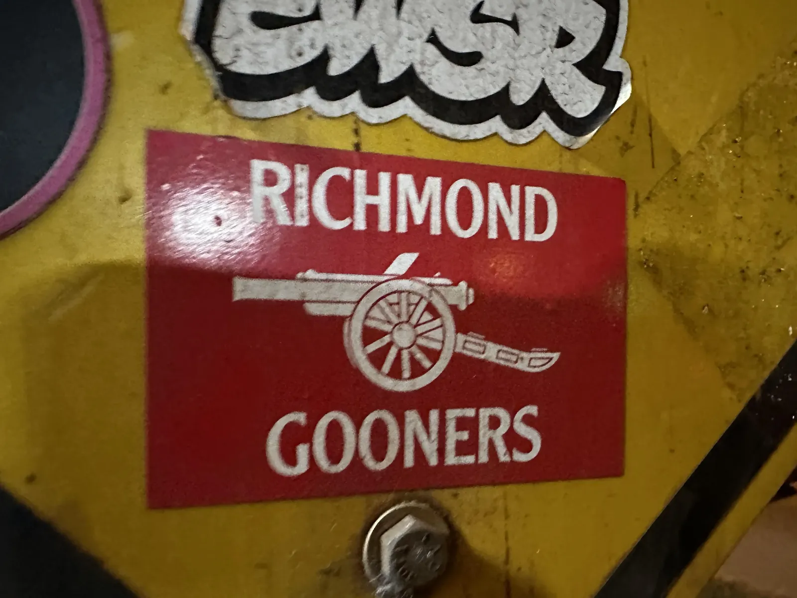 A red Richmond Gooners cannon-logo sticker stuck on a street sign